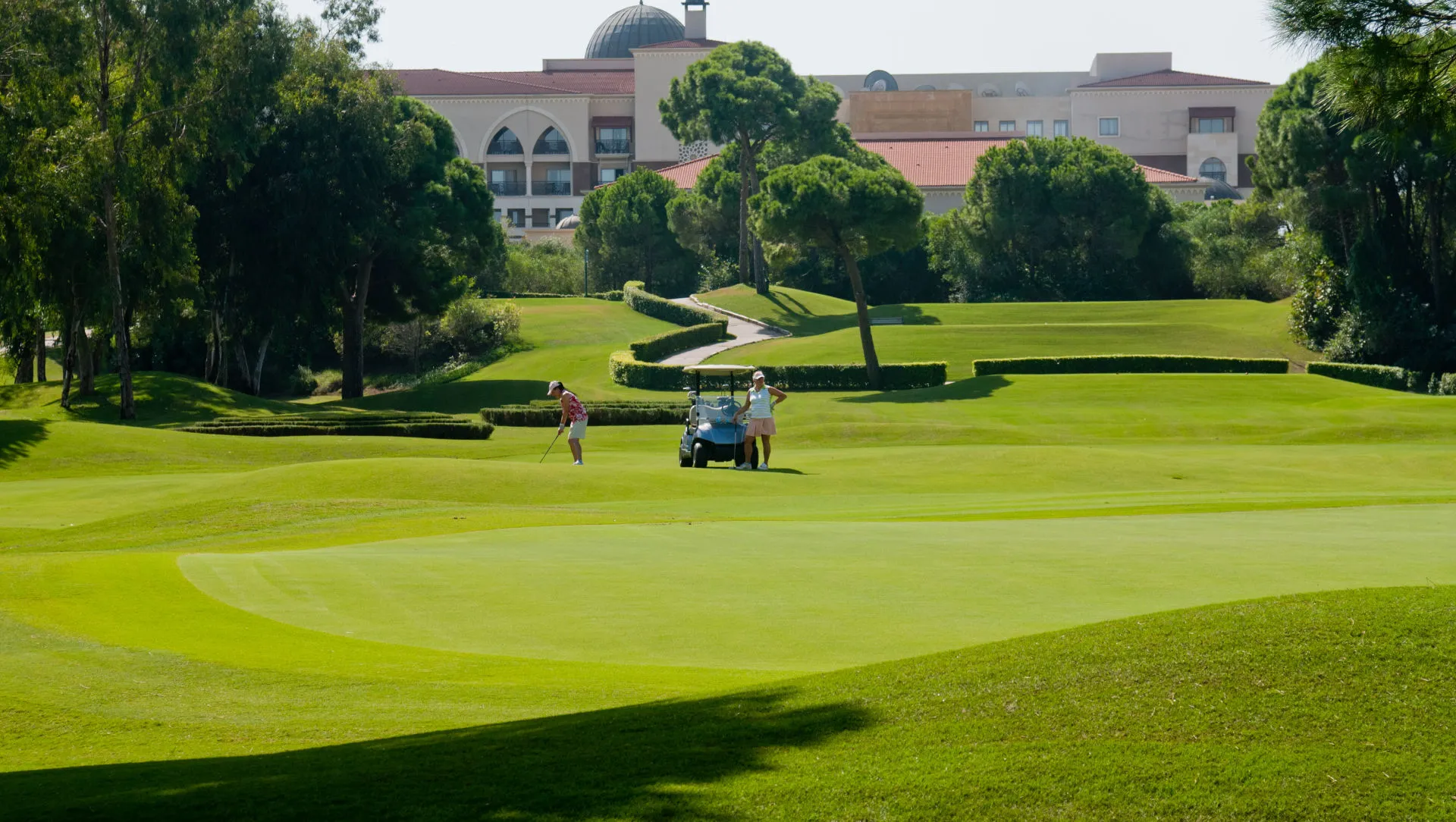 Fairway mit Golfcart vor dem Clubhaus